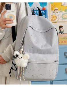 Grey star print school backpack detail, casual student bookbag with plush pendant and pockets.