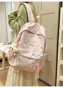 Pink star print student backpack with cute plush charm, multi-compartment casual school bag.