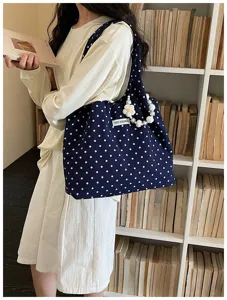 Dark blue polka dot canvas shoulder bag with pearl flower pendant, casual daily tote style.