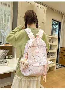 Pink star pattern school backpack with multi compartments and cute plush pendant for student use.
