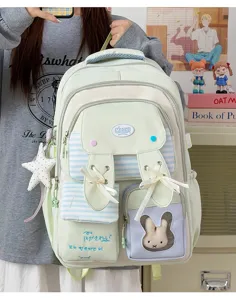 Cute pastel green school backpack for girls with bunny ears, ribbons, and cute plush doll.