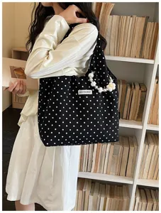 Detailed view of the cute black and white polka dot canvas shoulder bag with pearl strap.