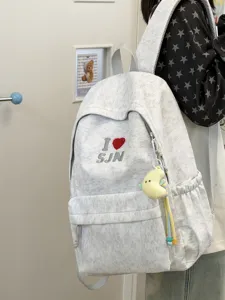 Detailed view of casual heather backpack featuring front embroidered heart pattern and cute pendant.