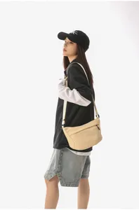 Vista detallada del bolso cruzado de nylon casual llevado por la modelo urbana.