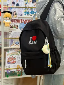 Detail view of the black canvas backpack featuring cute embroidery and plush moon charm.