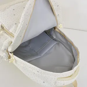 Beige star print school backpack open top view showing spacious interior lining and pockets.