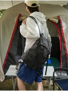 Detail view of lightweight black grid backpack, perfect for outdoor hiking and travel.