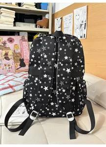 Detail view of the black star-patterned school backpack, showcasing multi-compartment design.