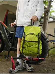 Lightweight green folding outdoor backpack detail, portable hiking daypack with pole straps.