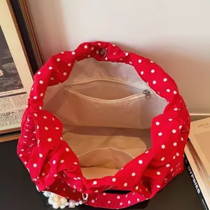 Red and white polka dot canvas shoulder bag with zipper pocket and magnetic closure.