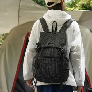 Lightweight black grid backpack for outdoor hiking and travel, model showing back view.