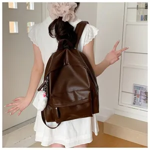 Vue détaillée du sac à dos décontracté en cuir PU marron foncé avec poche et joli pendentif.