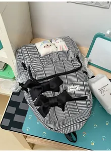 Detail shot of black and white striped backpack with cute bows, lace trim and plush bunnies.