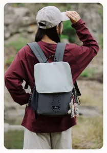 Outdoor casual two-tone backpack detail view showing adjustable straps and cute bear pendant.