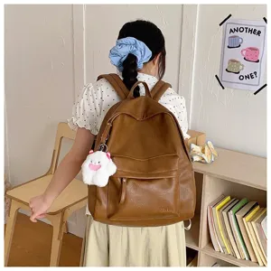Vue de detail du sac a dos en cuir marron avec grande capacite et charm en peluche doux.