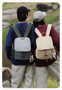 Outdoor lifestyle detail view showing stylish couple backpacks with cute bear pendants and straps.