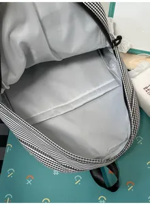 Black and white gingham backpack interior detail showing spacious compartment and durable lining.