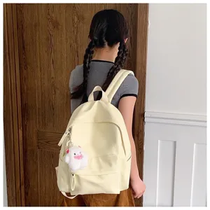 Sac à dos en toile unie minimaliste avec pendentif en peluche, grand sac d'école pour étudiants.