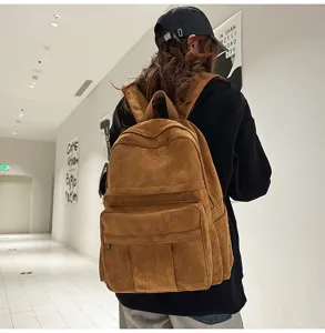 Detailaufnahme des braunen Vintage-Wildlederrucksacks mit Textur, Taschen und lässigem Stil.