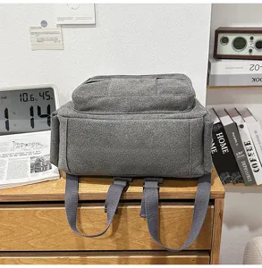 Grauer Rucksack aus robustem Stoff mit praktischen Fächern und bequemen Trägern für den täglichen Weg.