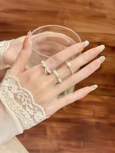 Gros plan détail de l'ensemble de bagues perles nœud, bague tendance pour femmes style chic.