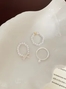 Gros plan détaillé de l'ensemble de bagues perles nœud, design élégant et finitions.