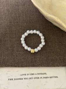 Bague élastique élégante en perles avec accent en métal doré côtelé pour un style chic.