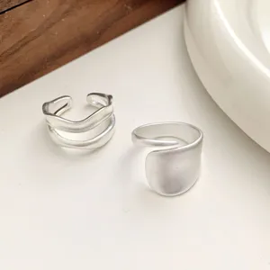 Close-up detail shot of matte geometric irregular open rings, minimalist stackable finger ring jewelry.