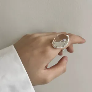 Primer plano detallado de un anillo abierto de plata con cristal transparente.