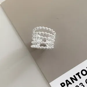 Close-up detail of a trendy multi-layer twisted silver ring, featuring a chic open band design.
