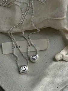 Sweet geometric heart and square pendant necklace with brushed matte finish and delicate beaded chain.
