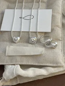 Minimalist matte silver geometric necklace and ring set with cute smile design for women.