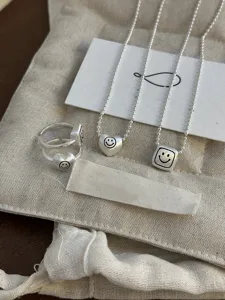 Matte silver geometric heart square necklace ring set detail showing fine brushed texture.