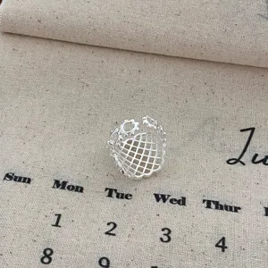 Close-up detail of the minimalist silver hollow grid geometric open ring, unique design.