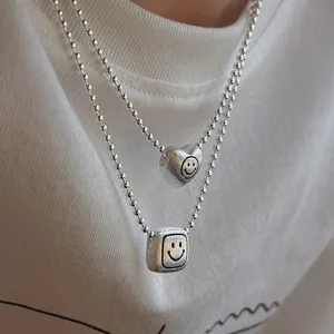 Double layer silver color bead chain necklace with cute heart and square smiley face pendants.