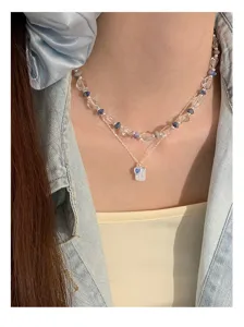 Close-up detail of double layer sweet blue heart necklace with crystal beads and silver chain.