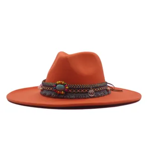 Vue détaillée du chapeau de jazz en feutre orange à large bord avec bande à franges perlées.