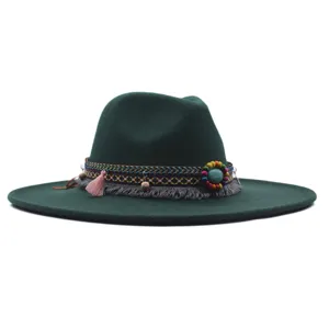 Vue détaillée du chapeau fedora vert foncé avec bande tissée ethnique colorée et pompons.