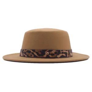 Gros-plan du chapeau fedora plat en laine camel avec une ceinture léopard chic et un clou doré.