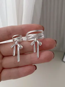 Detailansicht silberner Schleifen Ring mit gekreuzten Linien und Quasten Design elegant.