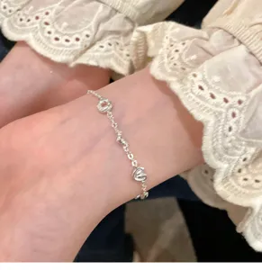 Close-up view of unique bread and heart shaped silver bracelet detail worn on wrist