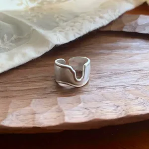 Primer plano detallado del anillo abierto mate ancho con un diseño de corte único y moderno.