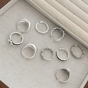 Close-up detail of multi-style silver open rings set, vintage geometric design jewelry display.