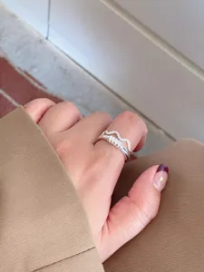 Detailed close-up shot of the silver geometric open ring worn gracefully on finger.