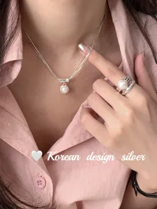 Collier en argent multicouche élégant avec pendentif perle et bague style coréen chic.