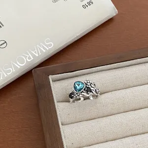 Vintage silver ring with blue crystal and floral design, stylish open adjustable fashion jewelry.