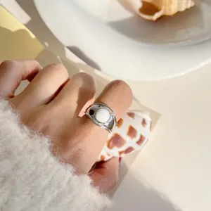 Closeup detail of the vintage geometric silver ring worn on finger with a white round stone.