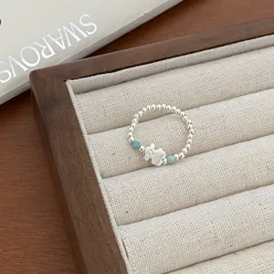 Delicate silver bead ring featuring a cute bear charm and turquoise accents, fine jewelry detail.