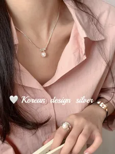 Image de détail d'un collier pendentif perle exquis, fine chaîne en argent avec éclat élégant.