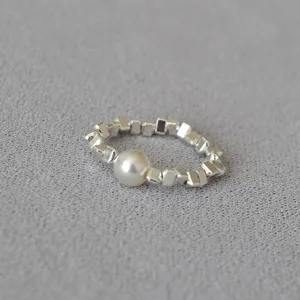 Detailed close-up view of the unique irregular faceted bead ring with an elegant white pearl.